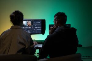 Synthesia’s Avatar Video Platform Is Cornering Loom’s Async Base A professional desk setup with screens displaying video editing software for async communication