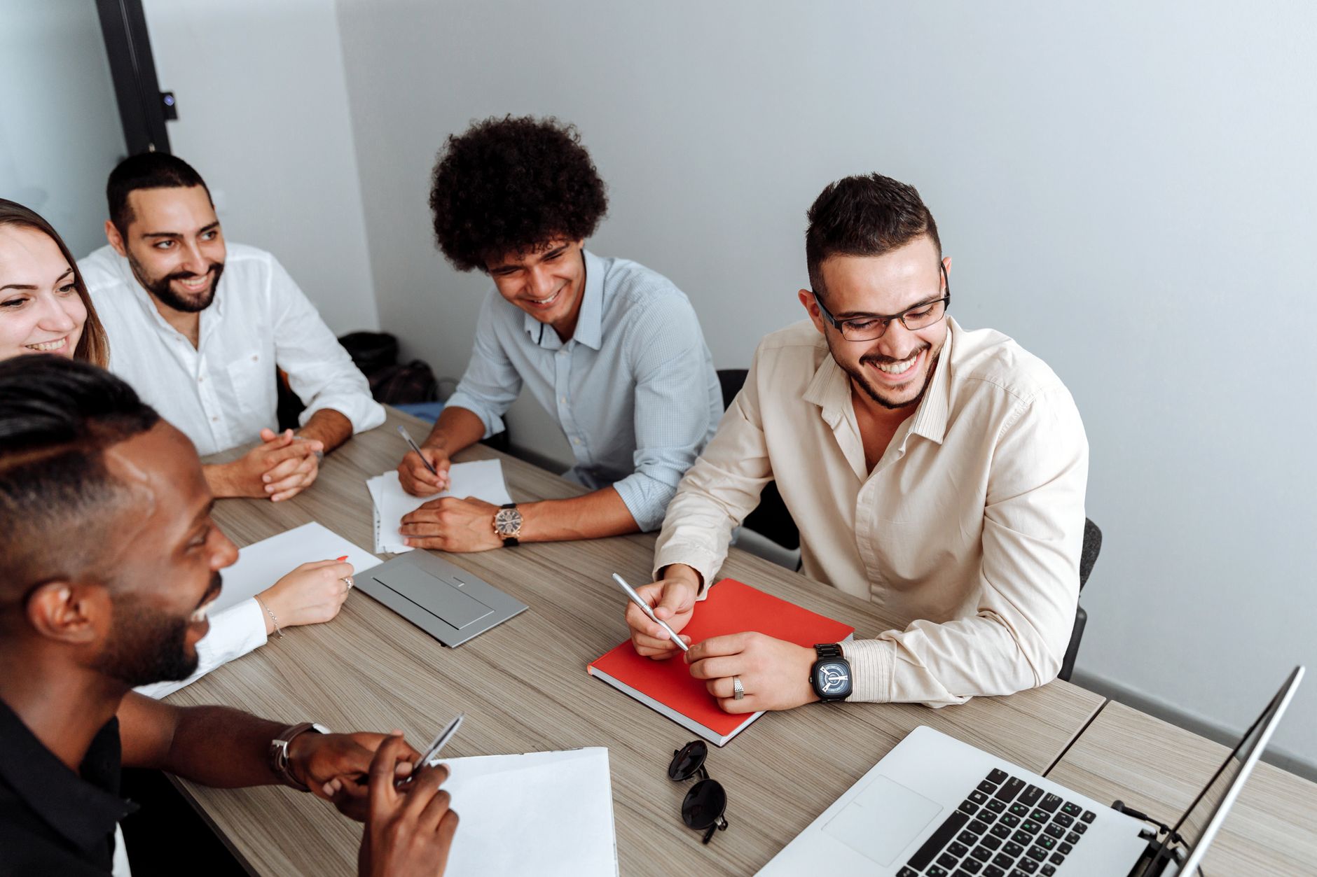 Small startup team collaborating around a table reviewing a product interface