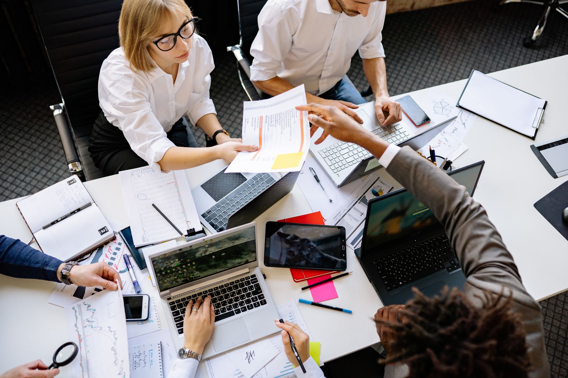 Business professionals reviewing AI tools on laptops during an enterprise meeting