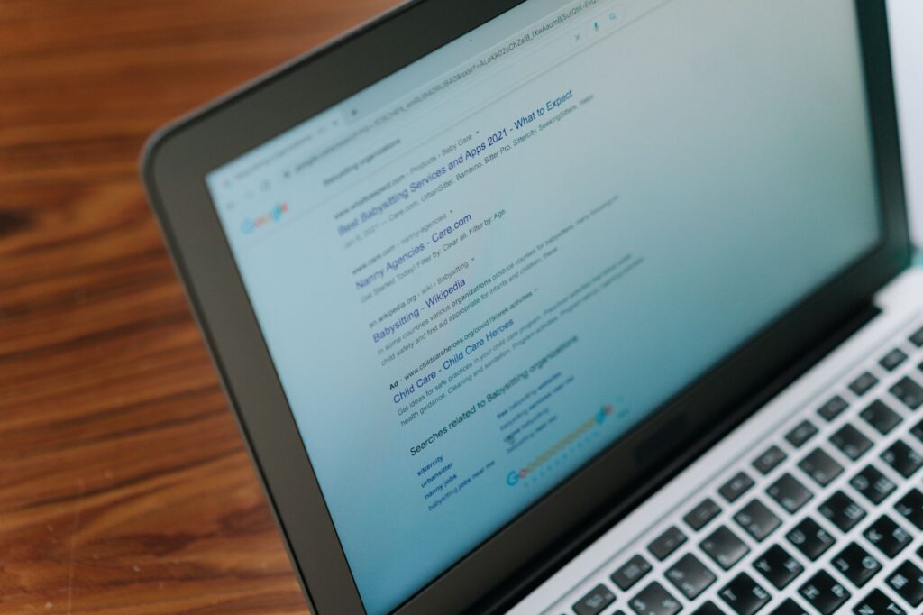 Person working on a laptop with multiple browser tabs open in a modern workspace