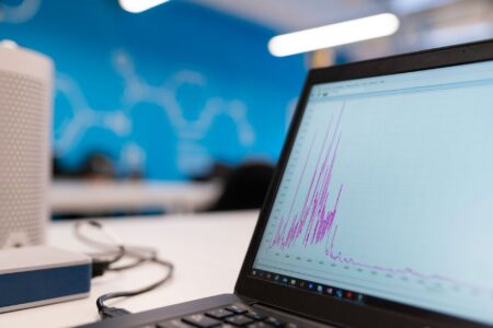 A data analyst reviewing collaborative notebook software on a monitor