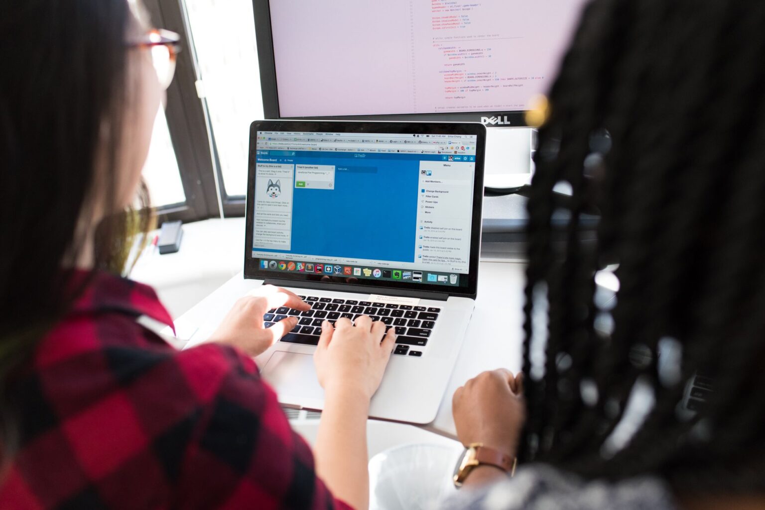 Two developers working together on a shared screen building a web application