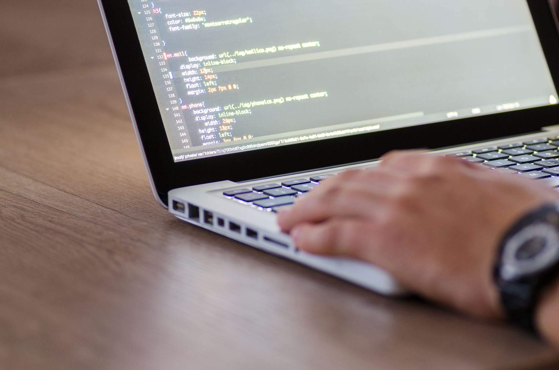 Developer working on a laptop with code on the screen