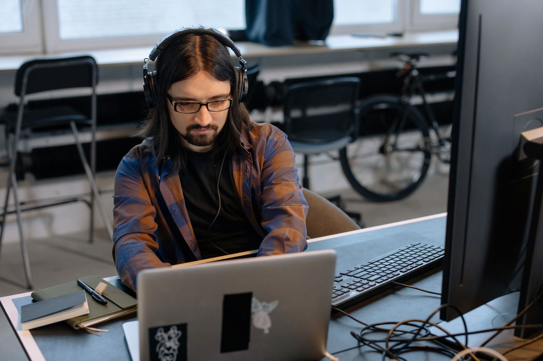 Developer focused on laptop screen with code visible in dark mode editor
