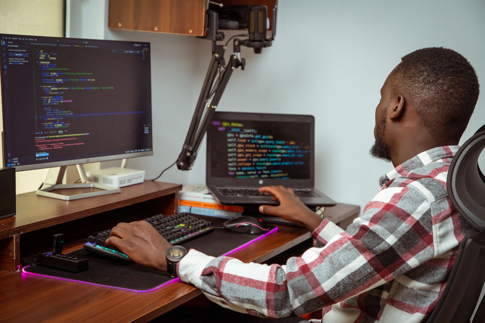 A software developer working at a desk with multiple monitors showing code and data visualizations