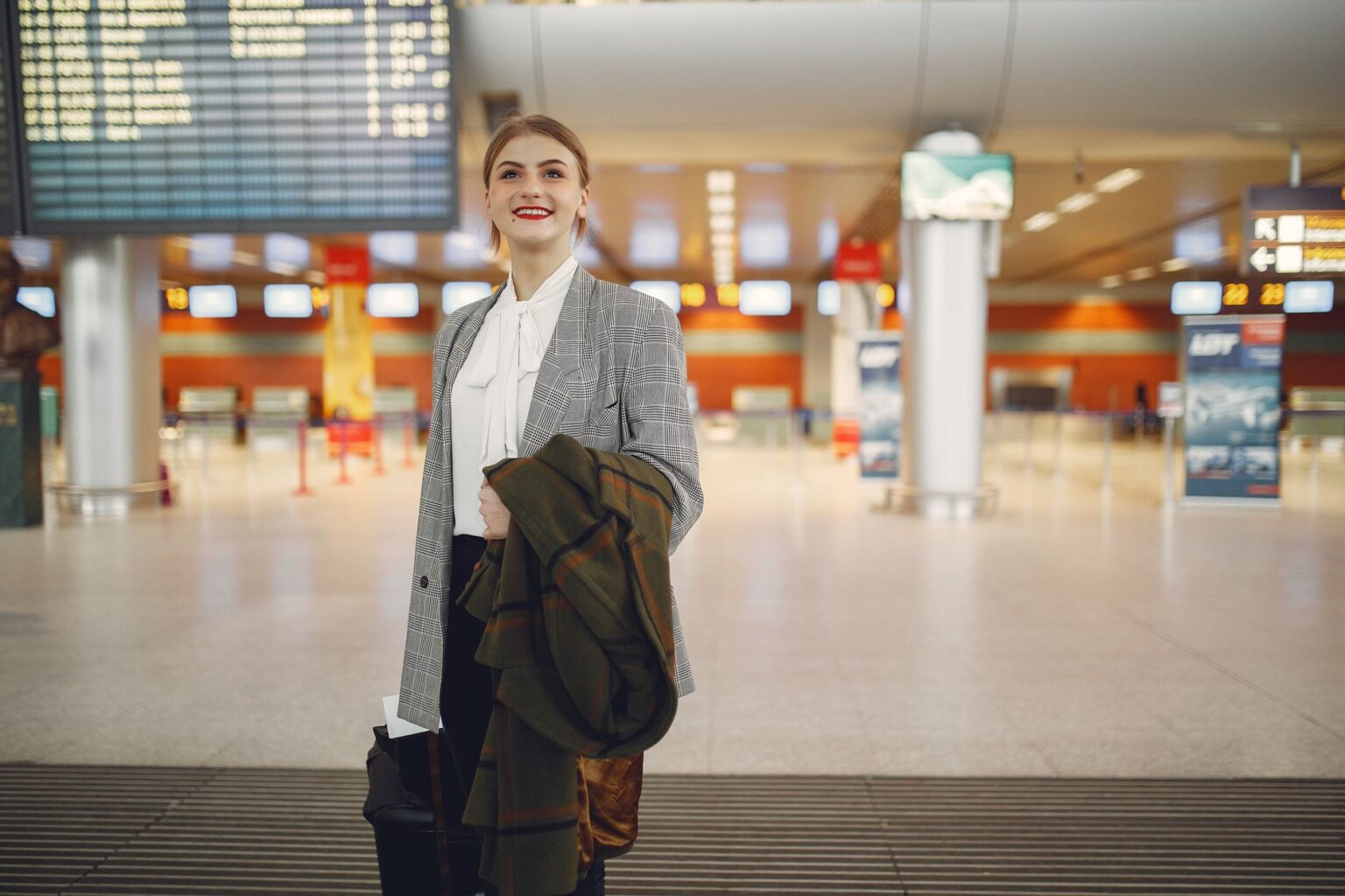Business traveler walking through a modern airport terminal with luggage