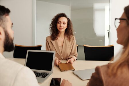 Two professionals conducting a job interview across a desk in a modern office setting